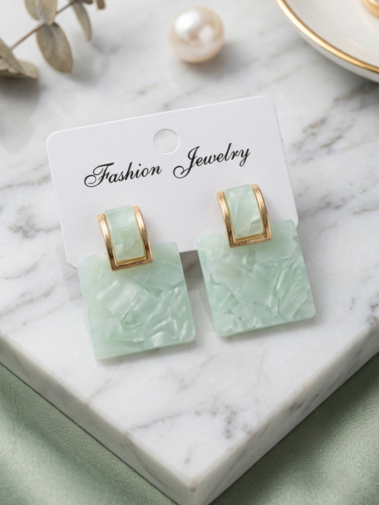 Mint green marble-effect square drop earrings with gold-tone rectangular tops on a jewellery display card.