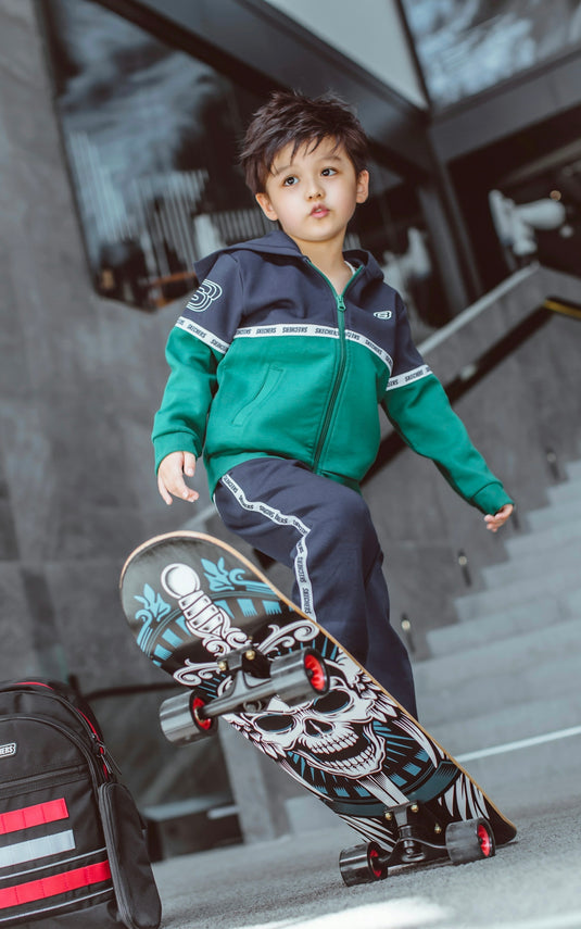 boy in green and blue zip up jacket riding on red and black motorcycle