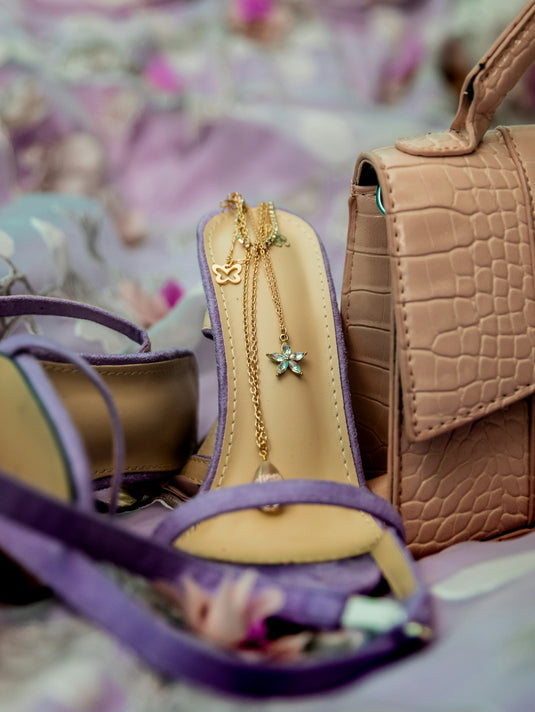 a pair of shoes and a purse on a bed