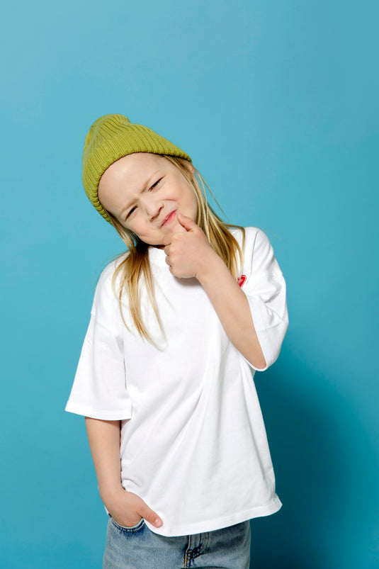 a young girl wearing a green hat posing for a picture