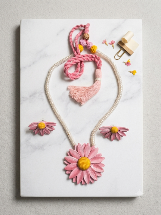 Handmade pink daisy clay necklace and matching floral earrings with yellow centres, pearl-look beads and pink tie cord.