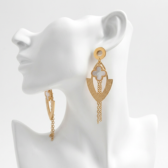 Gold-tone quatrefoil tassel earrings displayed on a white mannequin