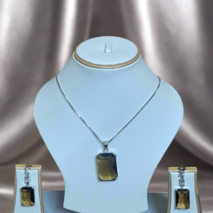 Elegant Smoky Yellow pendant set with CZ earrings and silver-plated chain by Garimas, displayed on a jewelry stand.