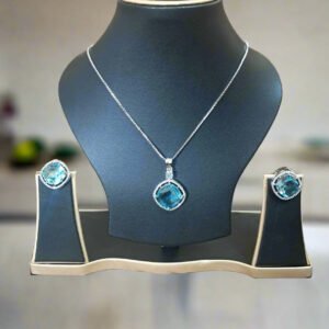 Aqua Blue Pendant Set with CZ studs and silver-plated chain displayed elegantly on a jewelry stand.
